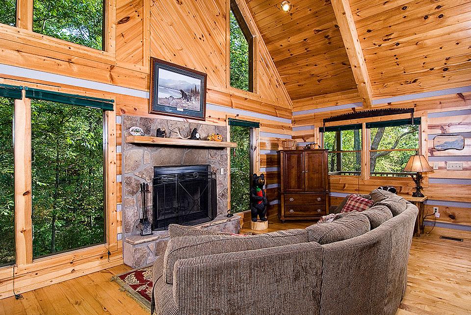 Cabin living with fireplace and wall of windows.
